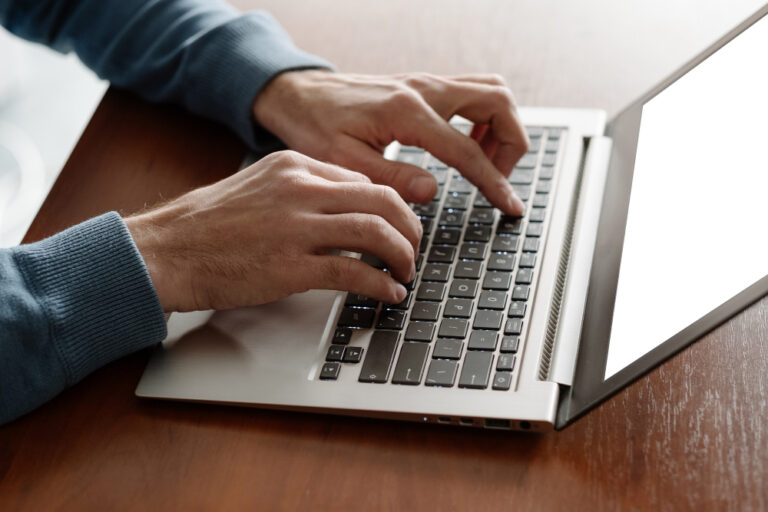 człowiek piszący na klawiaturze komputera